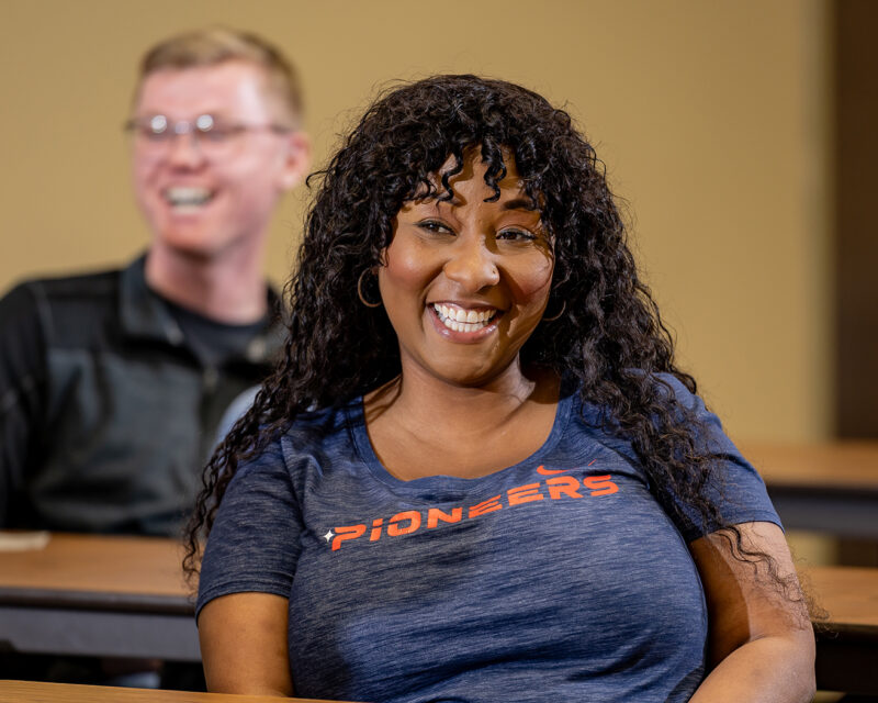 Students smiling in Customer Service program classroom.